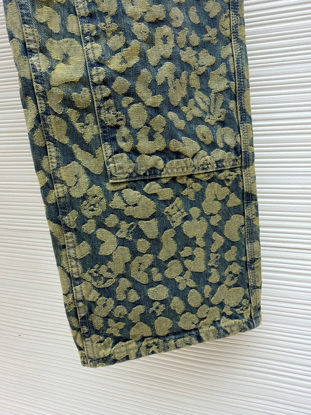 LOUIS VUITTON letter jacquard pearl buckle work denim trousers ●Original version: Purchased and developed by 14099 ●Item number: 1682239-B85 ●Material: denim fabric ●Technology: jacquard production ●Version: fitted version ●Weight: about 905 grams ●Size: 28-30-32-34-36 ●Description: These printed jeans are made of 12-ounce heavyweight denim. They are treated with enzyme washing and stone grinding. The fabric is soft and retains a crisp texture, while forming a natural distressed texture. The camouflage printing on the trousers adopts digital direct injection technology, and the ink penetrates into the yarn. The pattern color is firm, layered and not easy to crack and fall off. The shape is a loose straight cut, using three-dimensional cutting technology to fit ergonomics, and the crotch is reinforced with classic horsetail technology to improve wearing comfort and durability. The waistband is equipped with custom-made metal buttons and I-buckles, which have been treated with anti-oxidation plating and have a thick texture. The edges of the pockets are made of double-lane stitching, with fine and even stitching. The side seams and inseam are all hemmed, and every stitching is tightly stitched. The exquisite trousers-making craftsmanship and quality control are demonstrated in every detail. The overall wiring is straight and delicate, the fabric is comfortable and soft, and the color is consistent without color difference. It can be matched with the same style to create a fashionable look and control various occasions. Customized accessories, complete with three standards, same style for men and women!